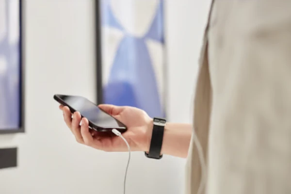 Hören oder lesen - Handy mit Kopfhörer in einer Hand