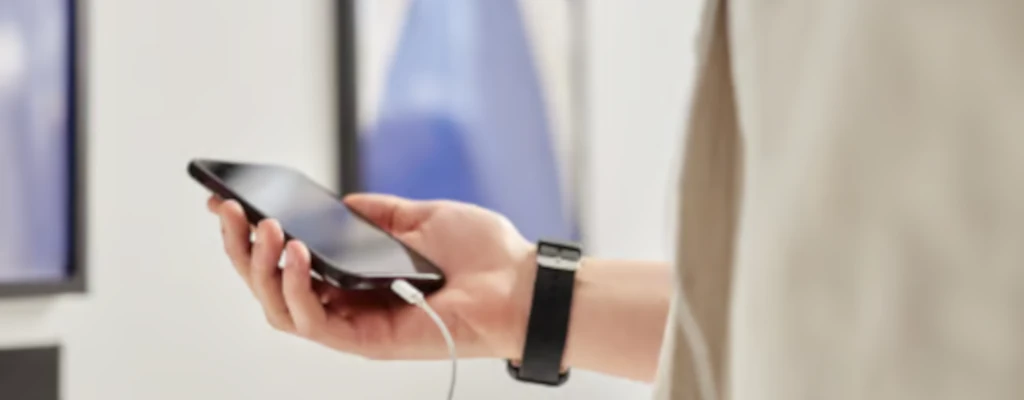 Handy mit Kopfhörer in einer Hand als Symbol für den Podcast