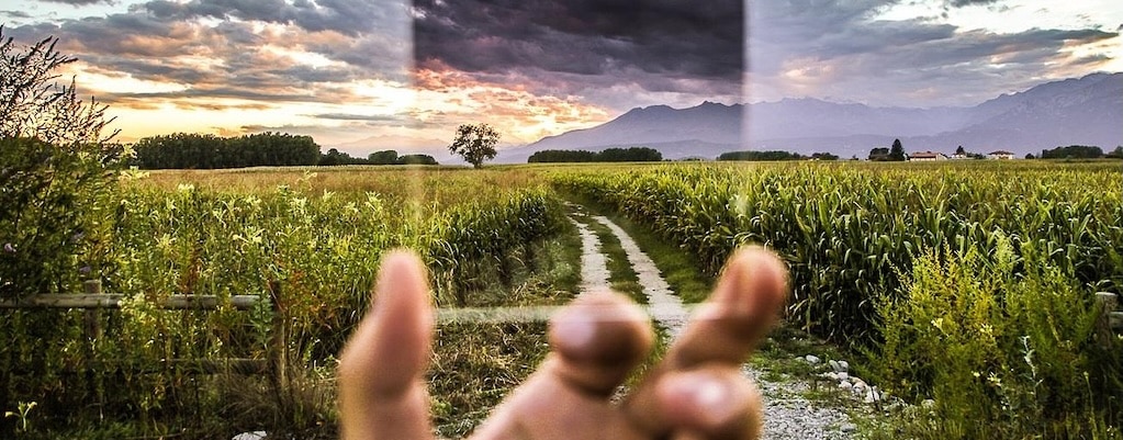 Eine Lupe vor einer Landschaft symbolisiert den Blick auf die Wirkung von Affirmationen