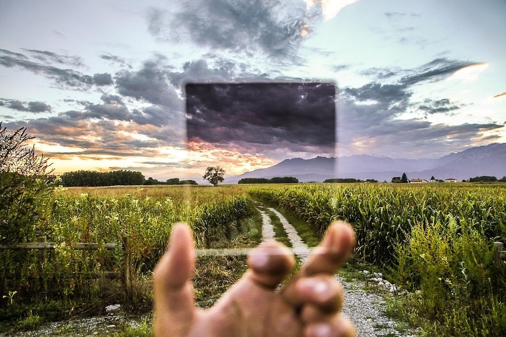 Eine Lupe vor einer Landschaft symbolisiert den Blick auf die Wirkung von Affirmationen